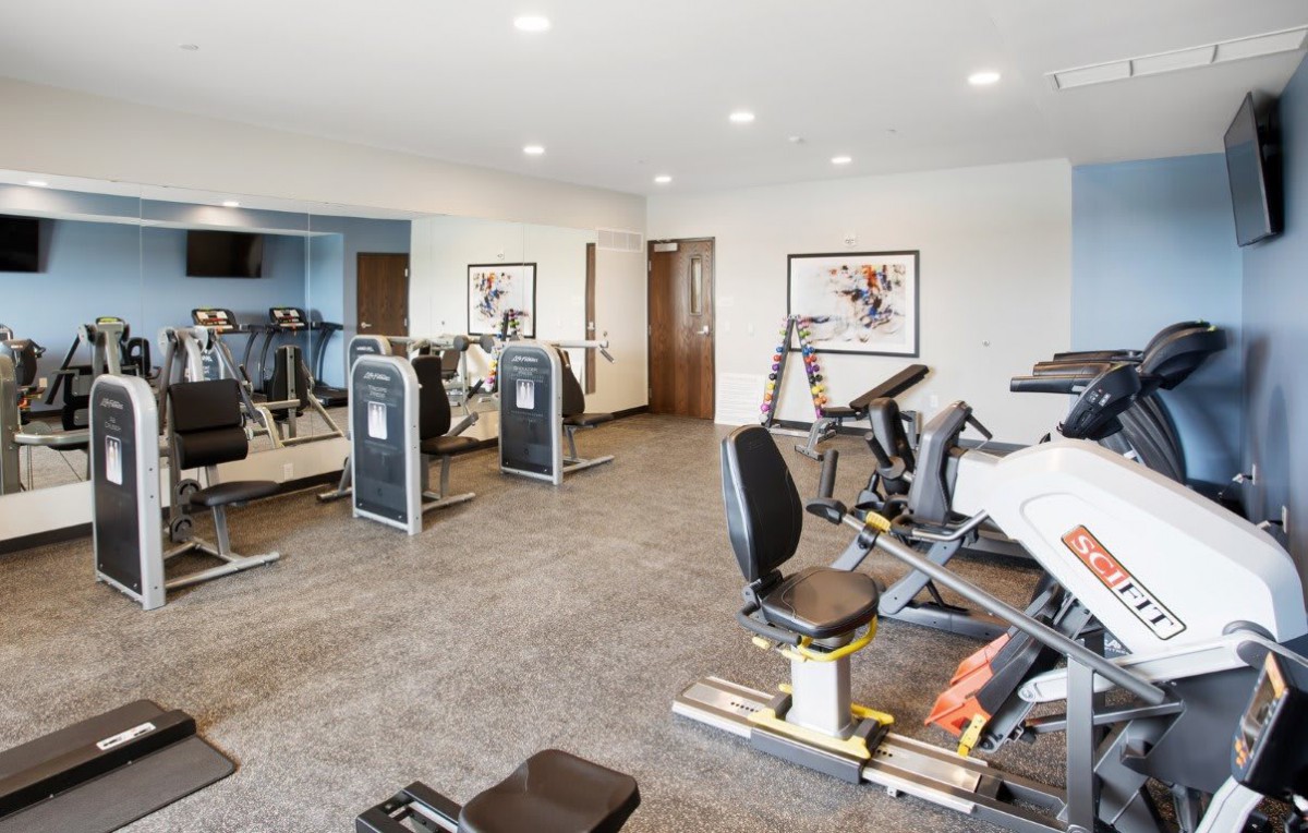 A modern gym equipped with various exercise machines and equipment.