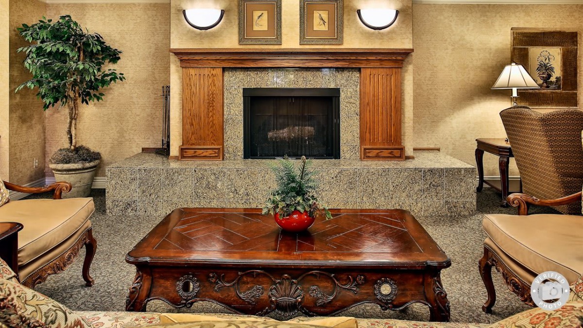 A stylish living room featuring a classic wooden coffee table and an elegant fireplace.