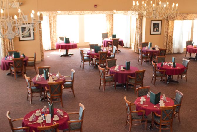 A well-lit dining room with elegantly set tables and comfortable seating.