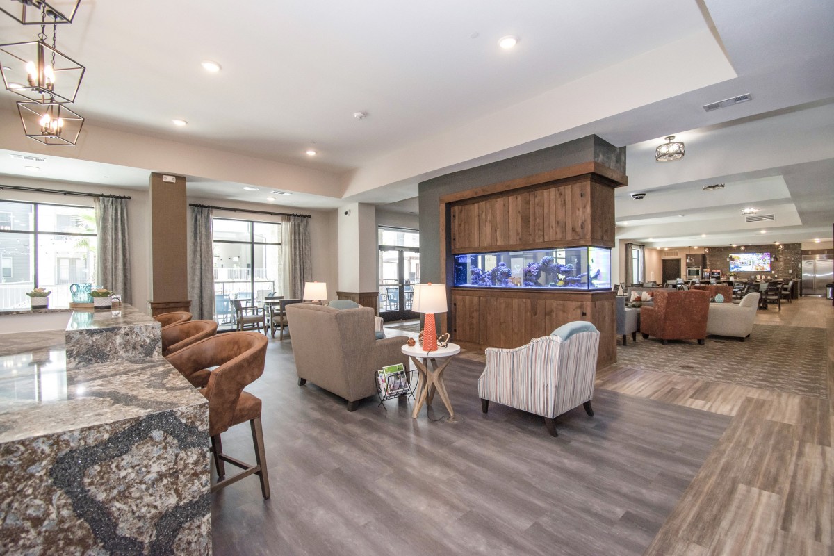 A modern and spacious living room with comfortable seating and wood flooring.