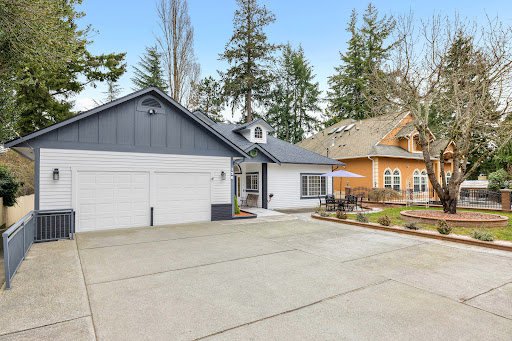 A modern residential home featuring a spacious driveway and beautifully landscaped surroundings.