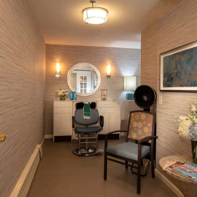 A cozy hair salon interior featuring a styling chair, mirror, and elegant decor.