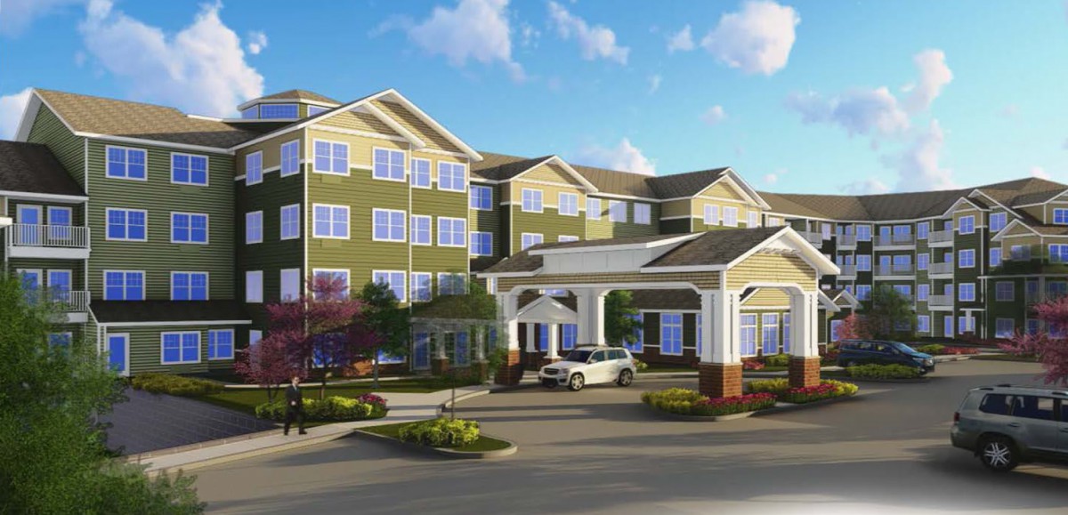 A four-story residential building with a landscaped entrance and a parked car in front.