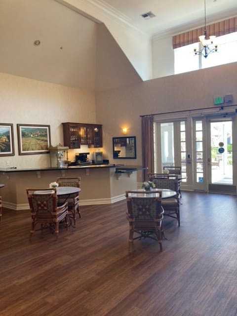 A spacious lobby with tables and chairs, decorated with artwork.