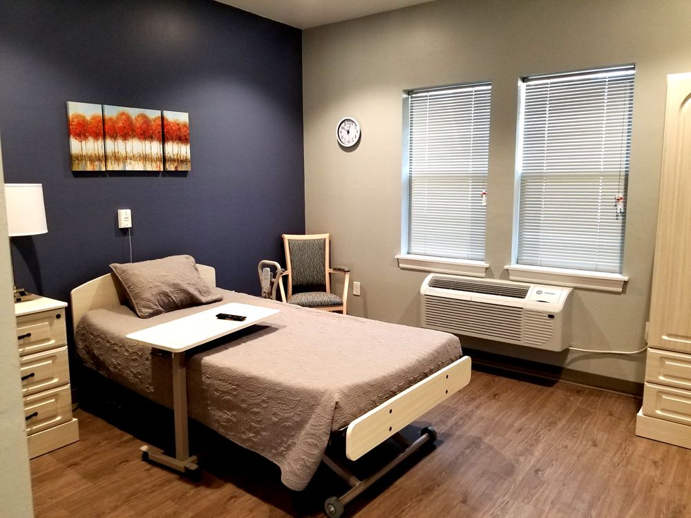 A clean and organized hospital room with a single bed and medical equipment.