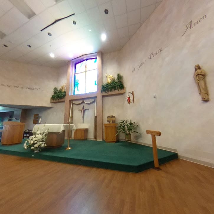 Interior view of a church altar with stained glass windows and religious icons.
