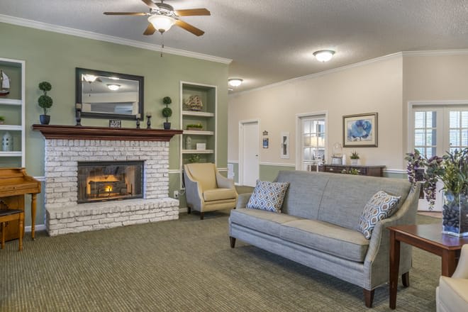 Cozy living room with a fireplace, sofa, and armchair.