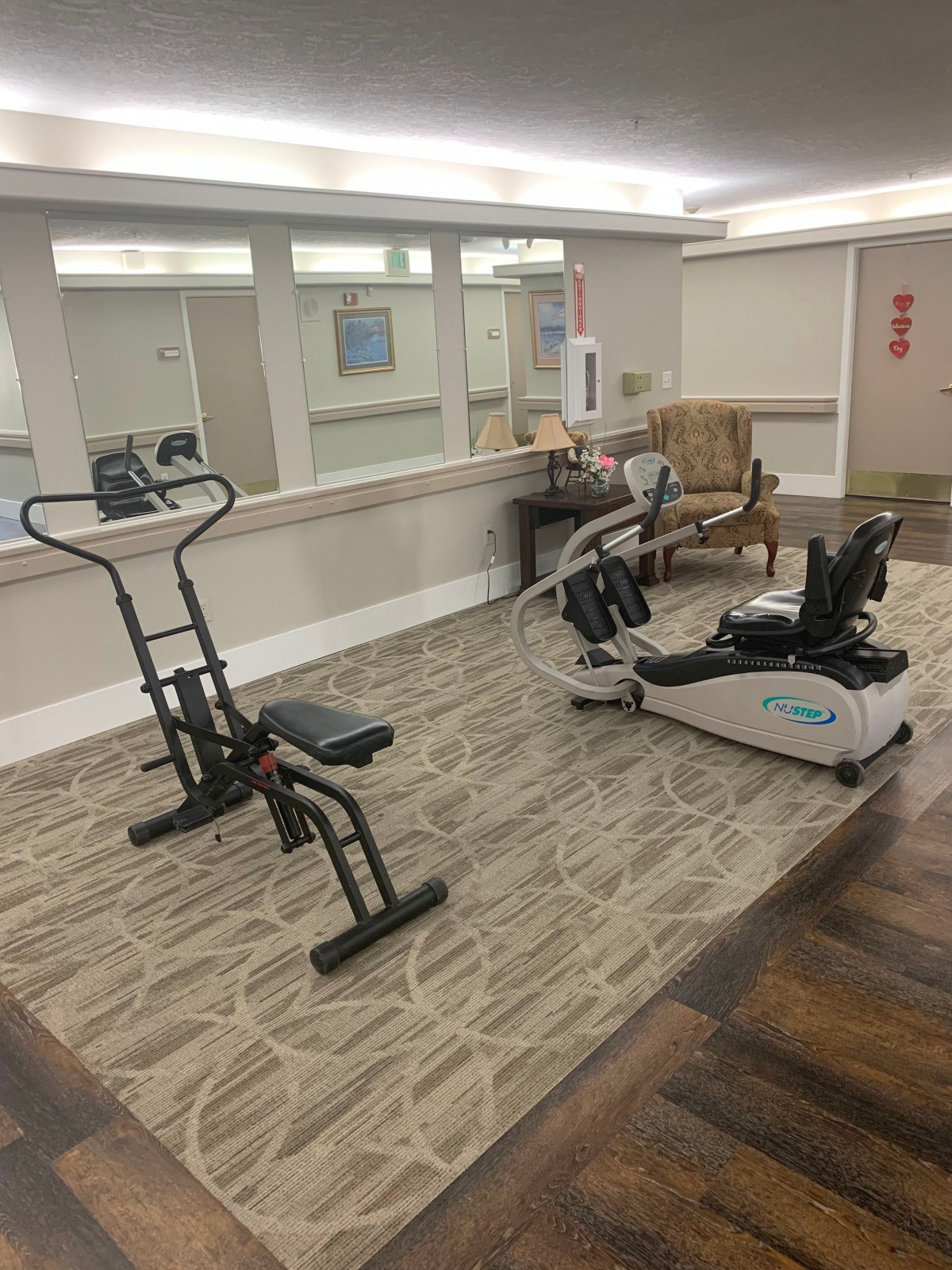 A small indoor gym with exercise equipment including a stationary bike and an elliptical machine.