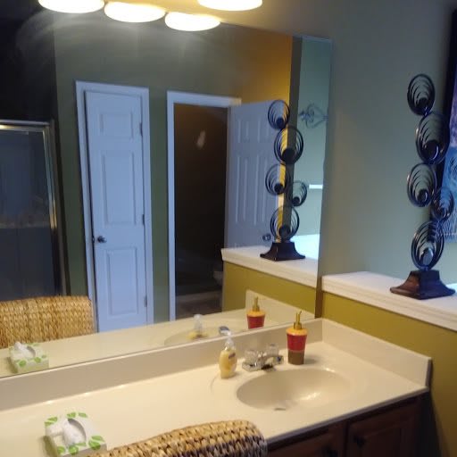 A well-lit bathroom with a mirror and neatly arranged counter items.