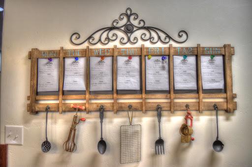 An elegant kitchen menu board featuring organized recipes and functional utensils.