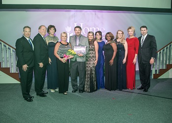 A group of individuals gathered to celebrate and recognize achievements at a formal awards event.