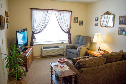 Cozy living room with a TV, sofa, and armchair.