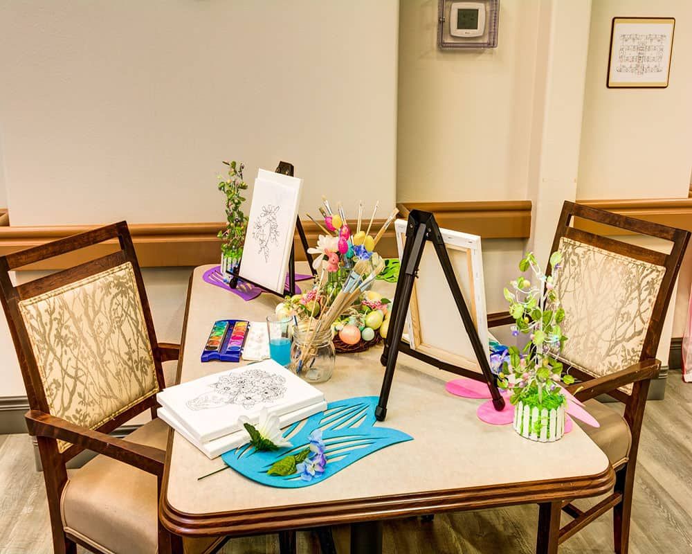 A table set up with art supplies, including coloring books and colored pencils, ready for a creative session.