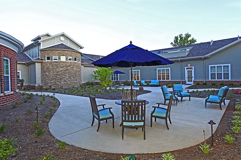 A patio area with seating and an umbrella outside a building.
