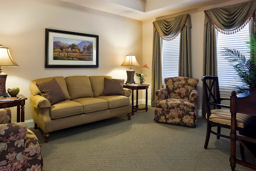 A cozy living room featuring a comfortable sofa, floral armchair, and warm lighting.