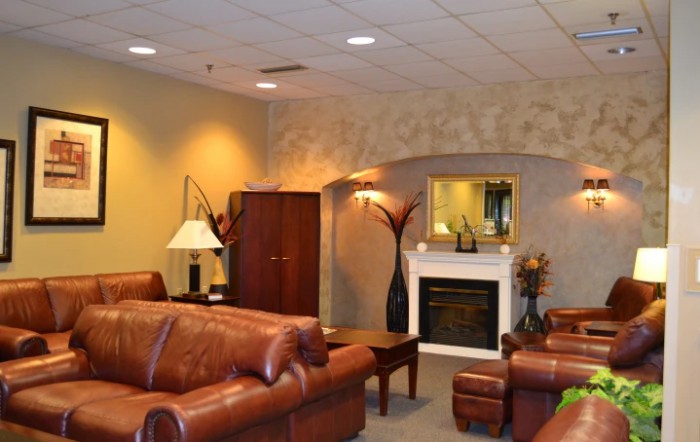 A cozy living room with leather sofas and elegant decor, featuring a fireplace.
