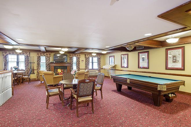 A cozy recreation room featuring a billiards table and seating area.