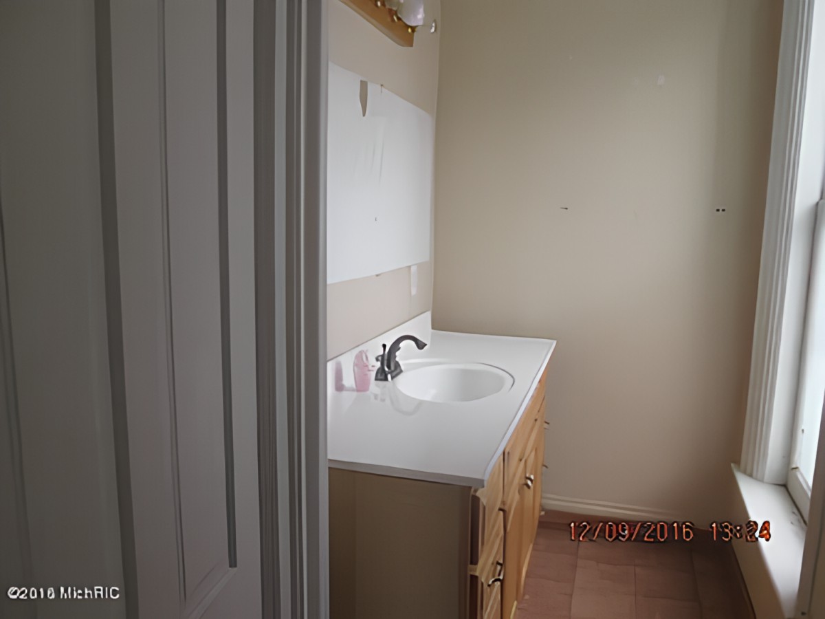 A bathroom featuring a white sink and a large mirror.