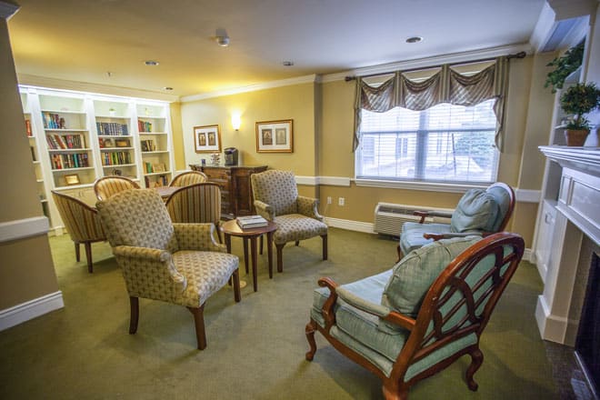 Cozy living room with comfortable chairs, a sofa, and a bookshelf.