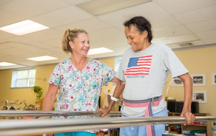 A therapist assists a patient with a walking exercise during a rehabilitation session.