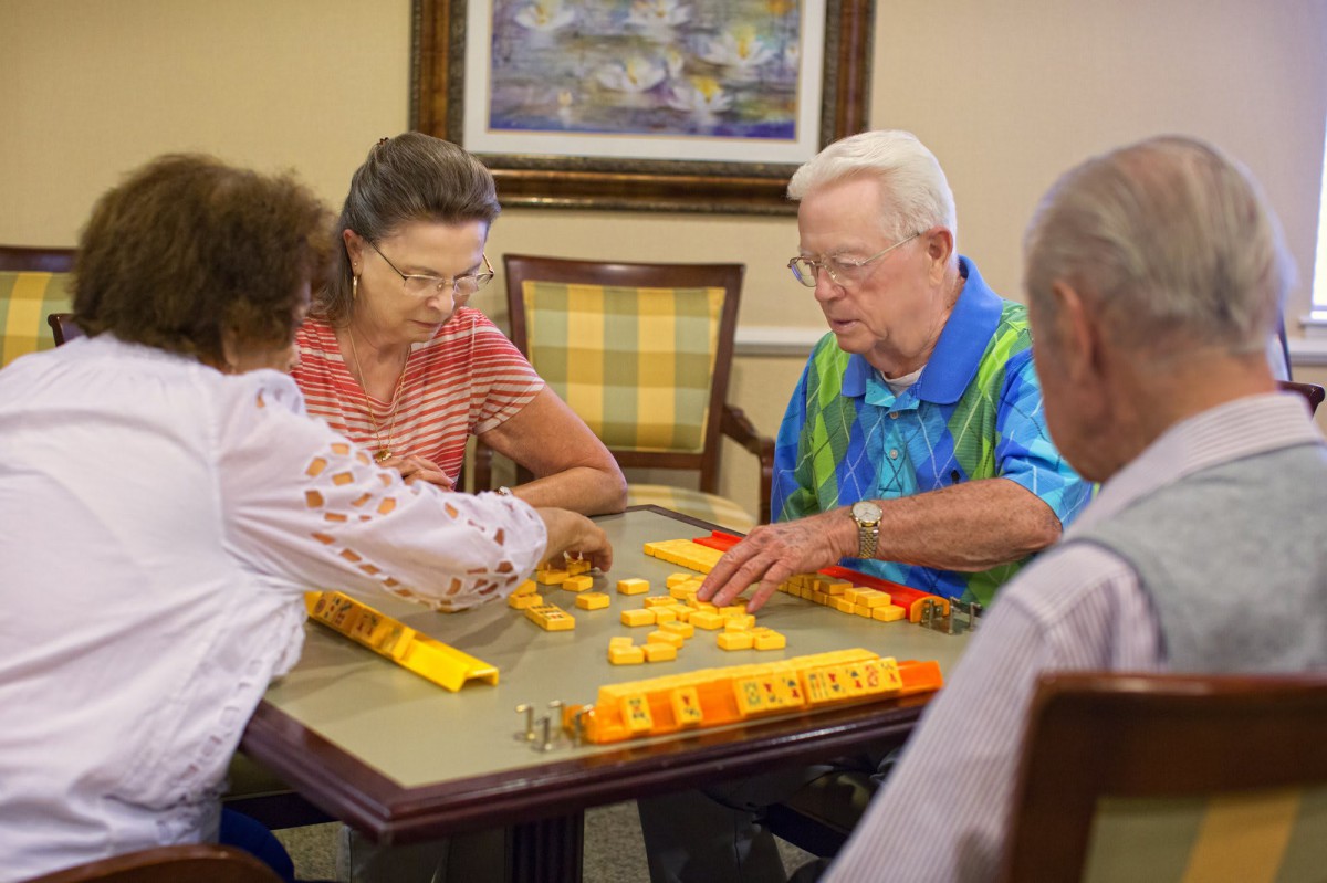 A group of seniors enjoying a board game together indoors.