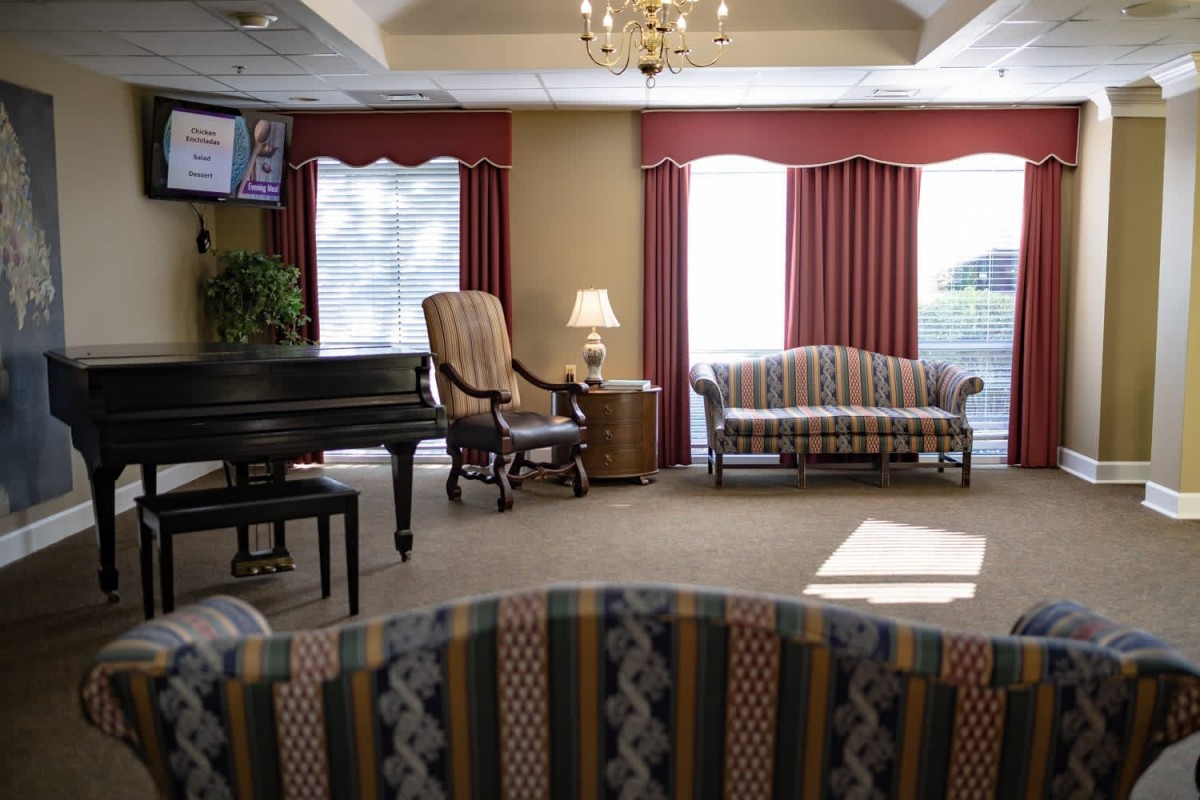 A cozy living room with elegant furniture and a piano.