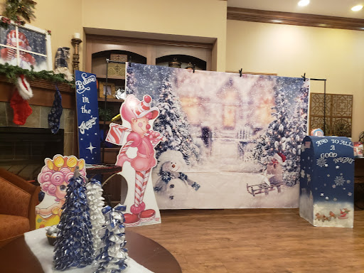 A cozy indoor holiday setup featuring winter-themed decorations and a cheerful pink character.