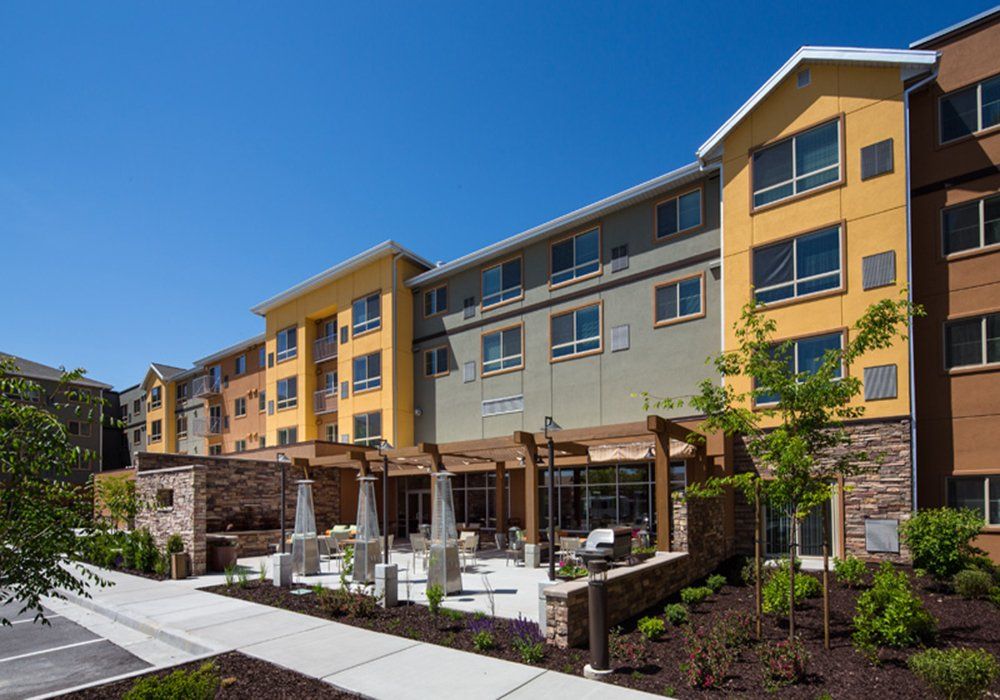 A modern hotel building with a landscaped outdoor patio area.