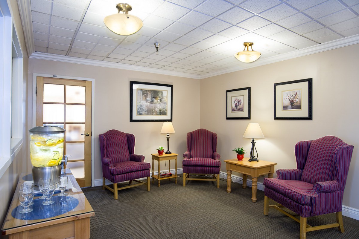 A cozy waiting room with purple chairs and ambient lighting.