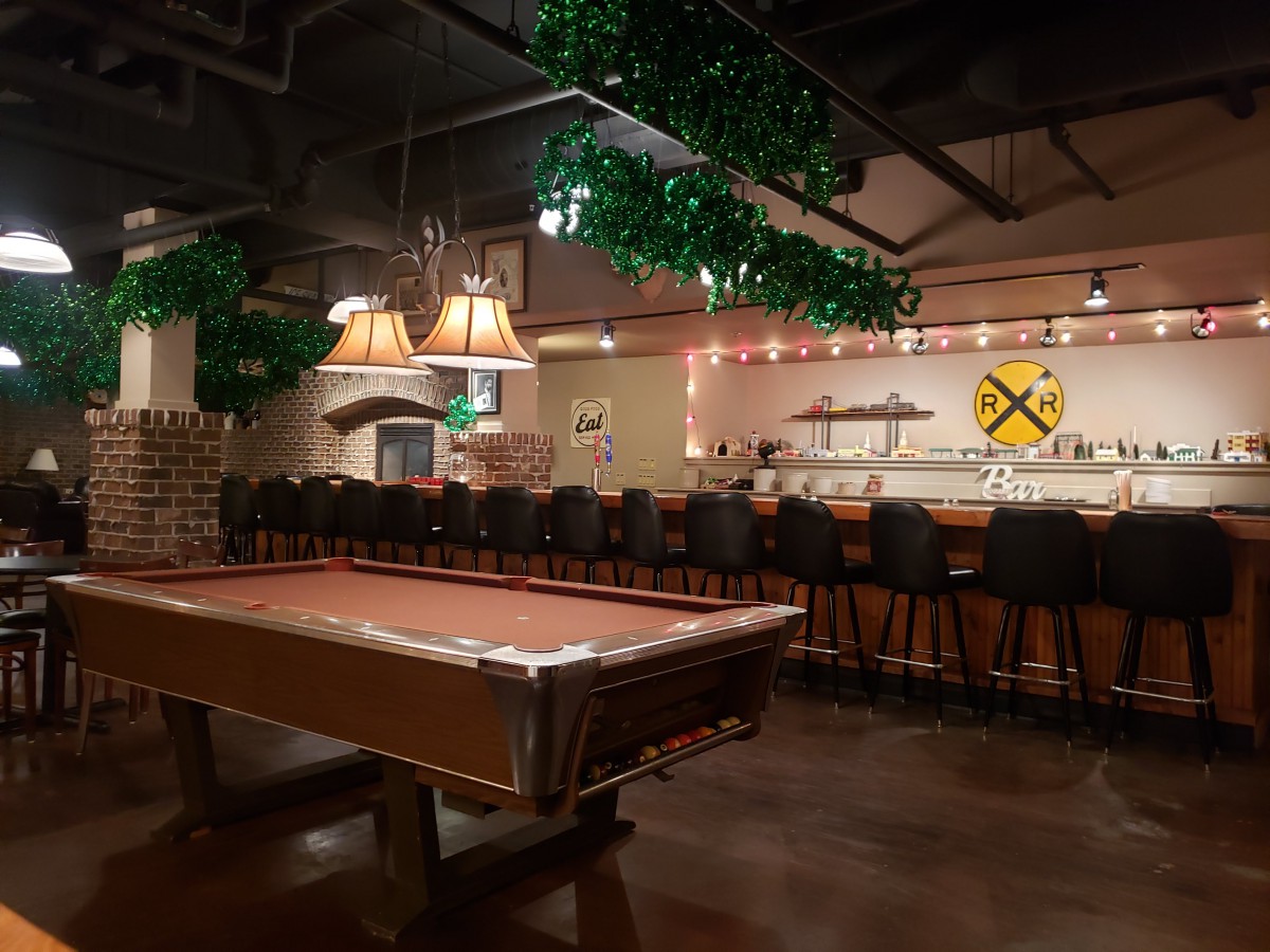 A cozy bar interior with a pool table and seating area.