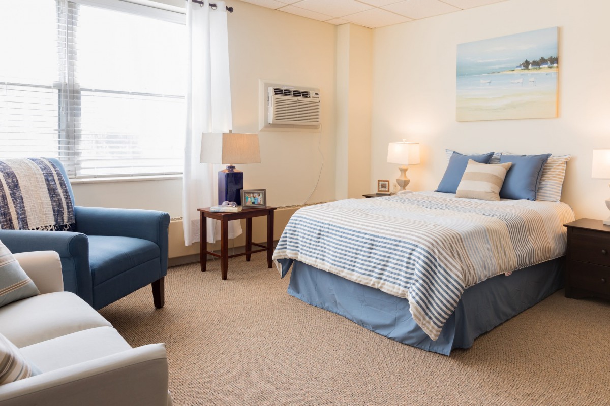 A cozy bedroom with a neatly made bed and comfortable seating.