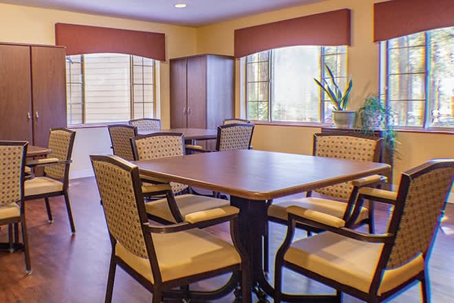 A cozy dining room with a wooden table and chairs, complemented by large windows and warm lighting.