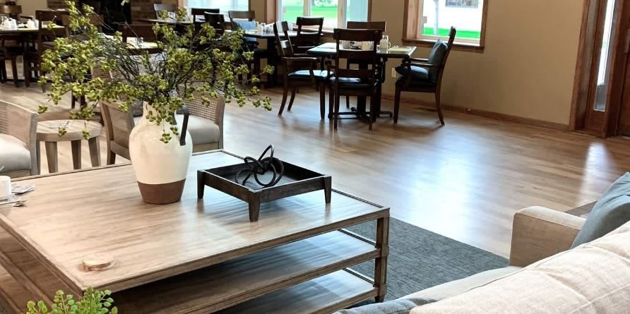 A modern cafe interior with tables, chairs, and decorative elements.