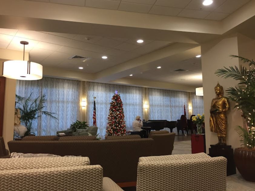 A cozy lobby featuring a decorated tree, seating area, and a piano.