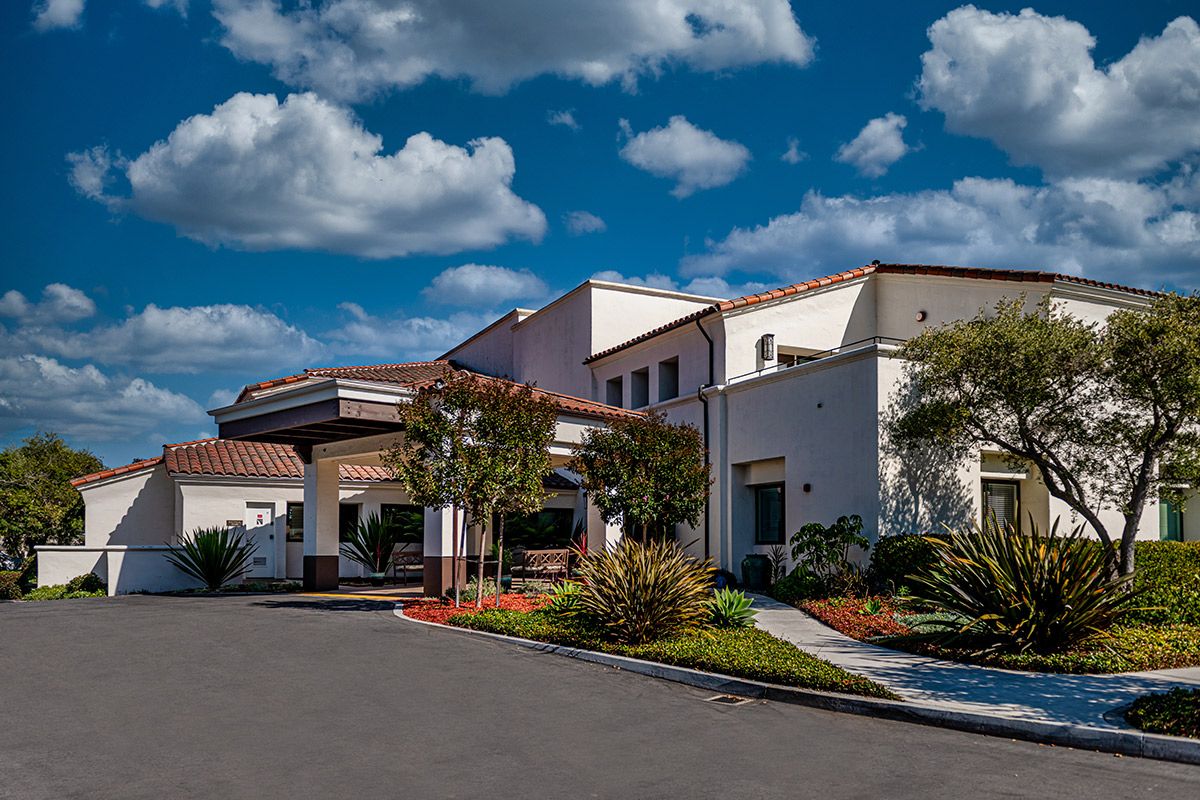 Modern medical facility with landscaped entrance under a bright sky.