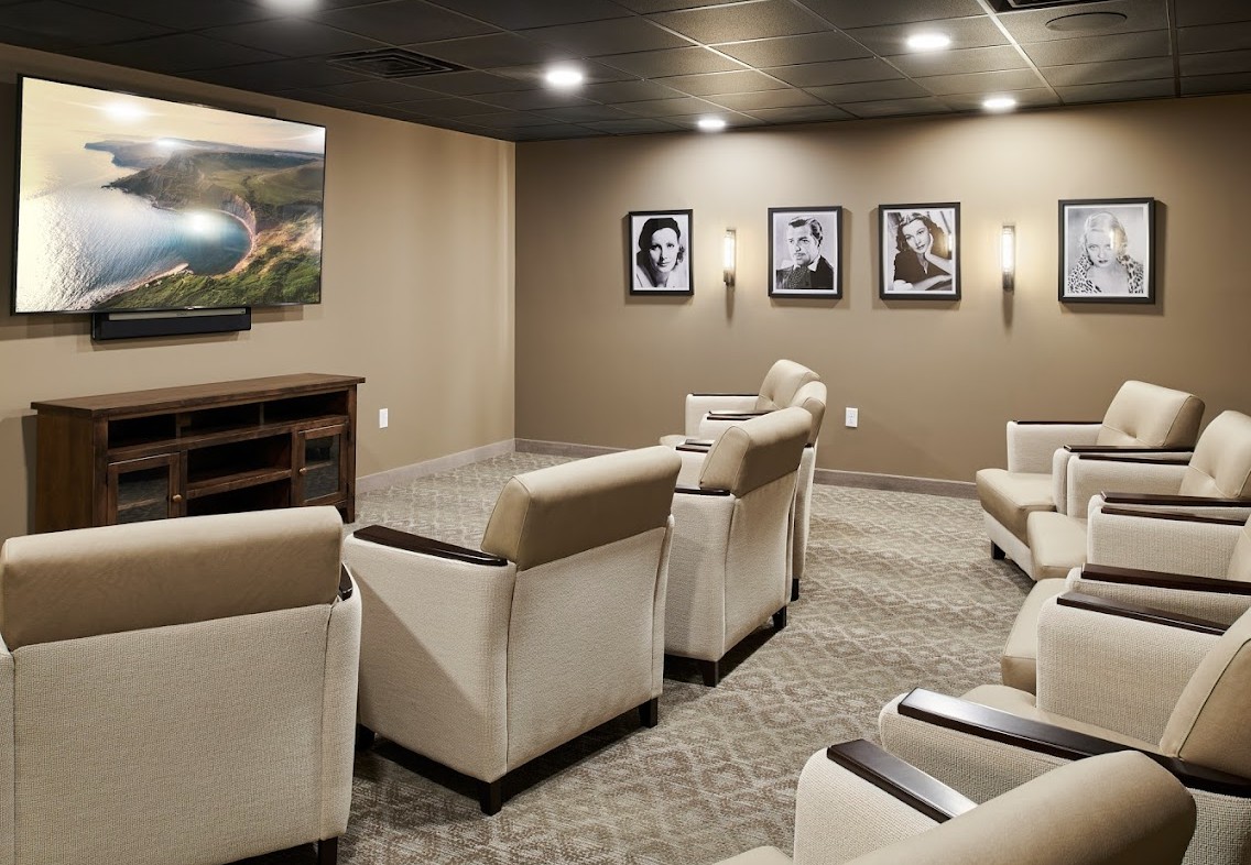 A modern home theater with comfortable seating and wall-mounted artwork.