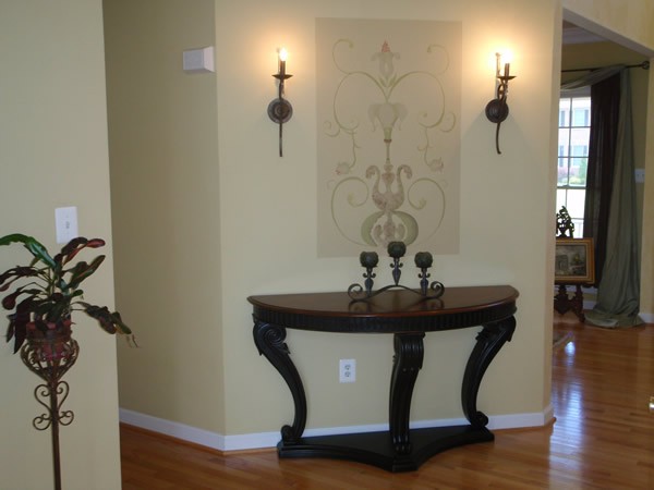 Elegantly decorated hallway with a console table, wall sconces, and candles.