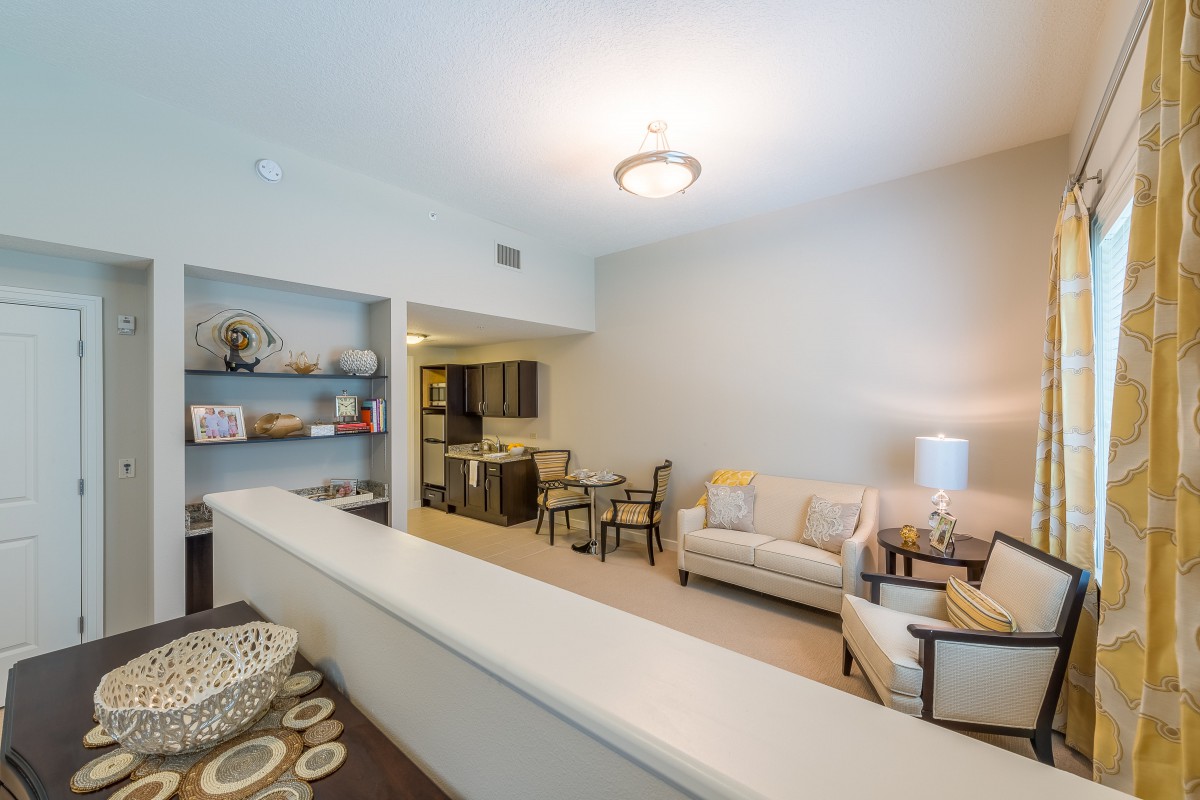 A modern apartment living room with a cozy sofa and dining area.