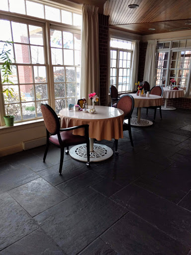 A cozy dining area featuring elegantly set tables, surrounded by natural light.