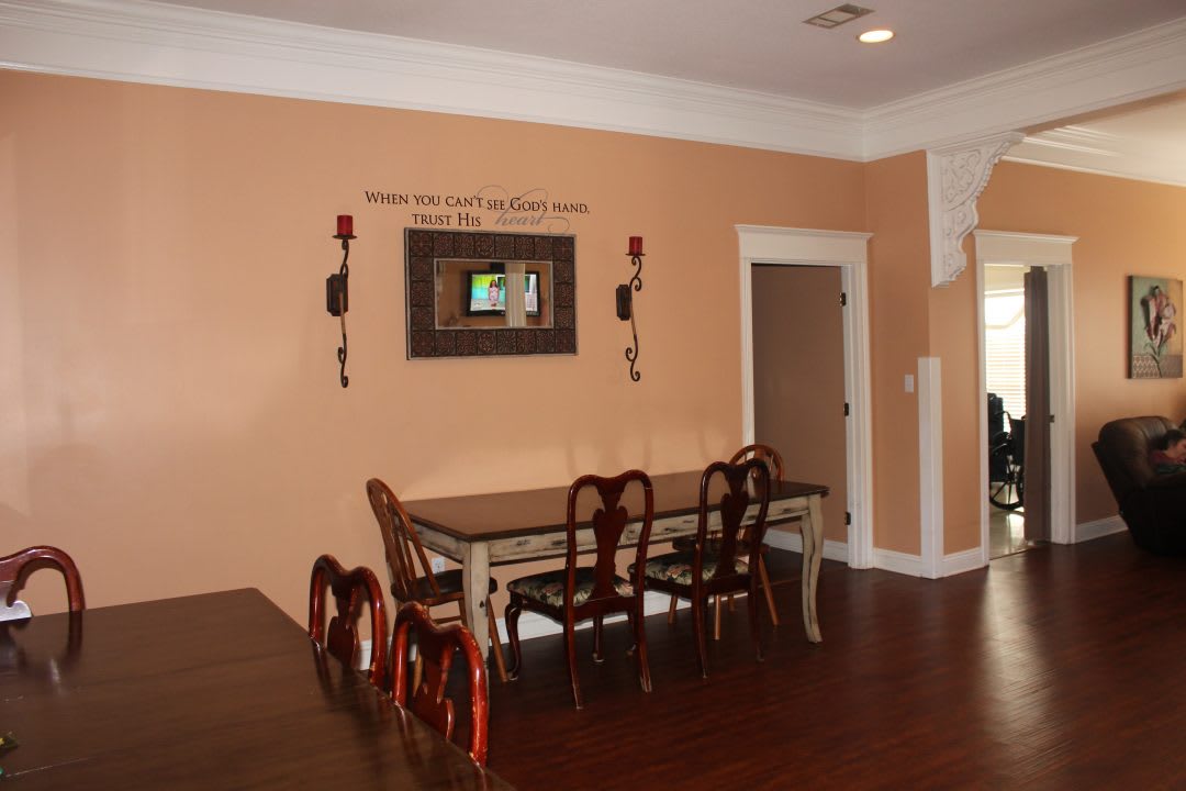 A cozy dining room with a wooden table and chairs, complemented by wall decor and warm lighting.
