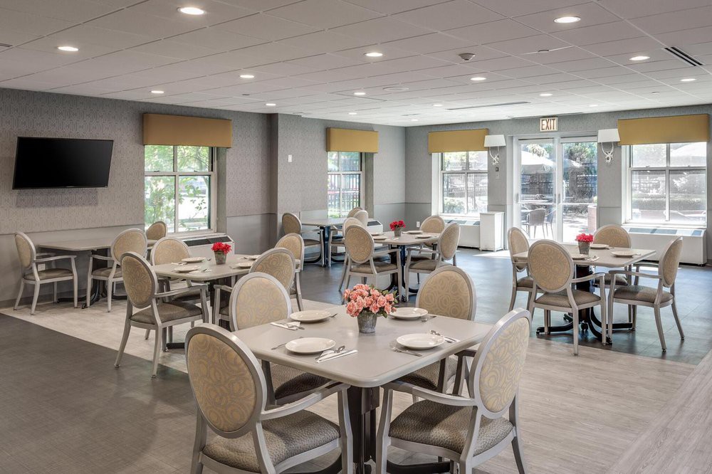 A modern dining room with neatly arranged tables and chairs, featuring a minimalist interior design.