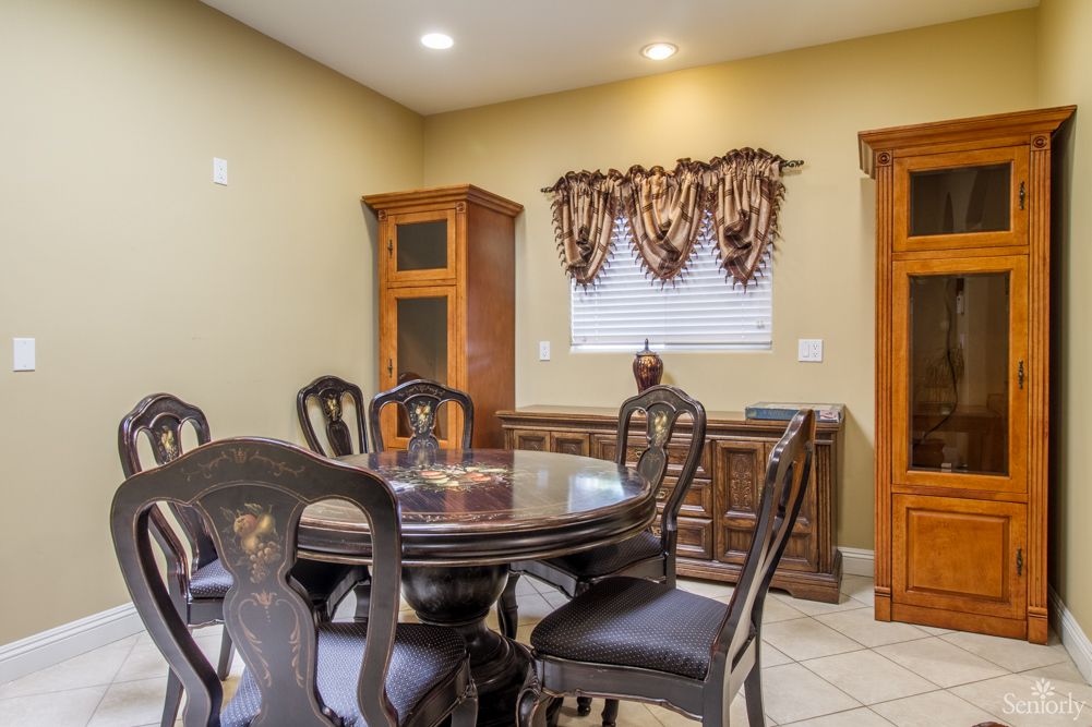 A cozy dining room with a round table, chairs, and wooden cabinetry.