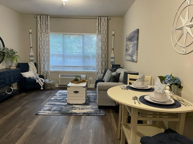 Cozy living room with modern decor, featuring a sofa, coffee table, and dining area.