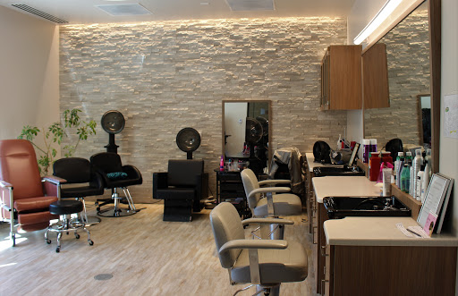 A modern hair salon featuring stylish barber chairs and a sleek interior design.