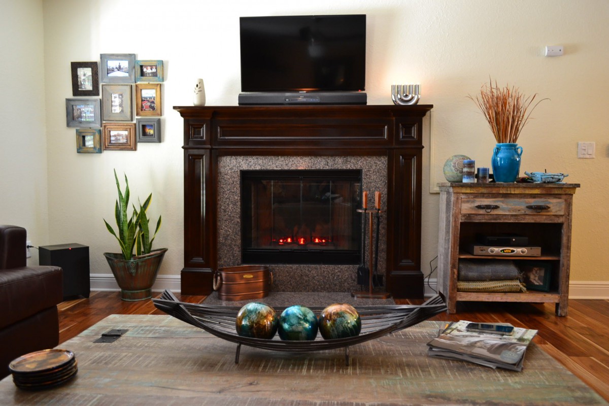 A cozy living room with a fireplace, television, and decorative elements.