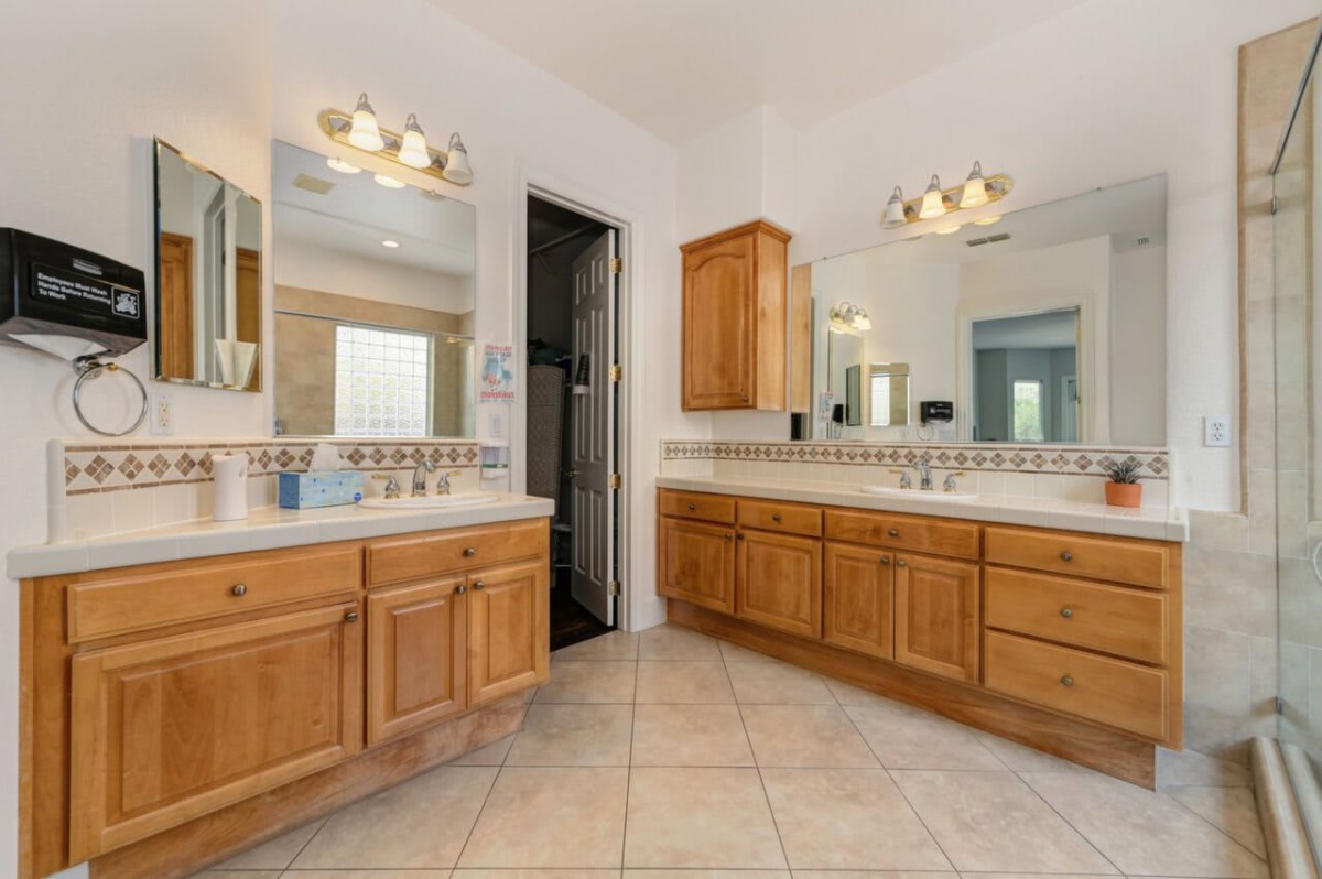 Spacious bathroom with double vanities and large mirrors.