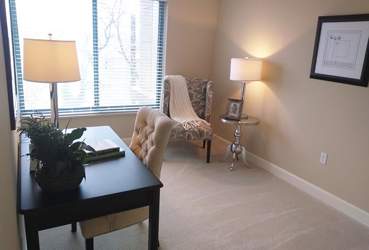 A cozy home office with a desk, chair, and lamps providing an inviting workspace.