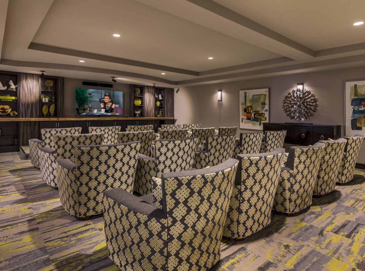 A cozy home theater room with patterned seating and a large screen for entertainment.