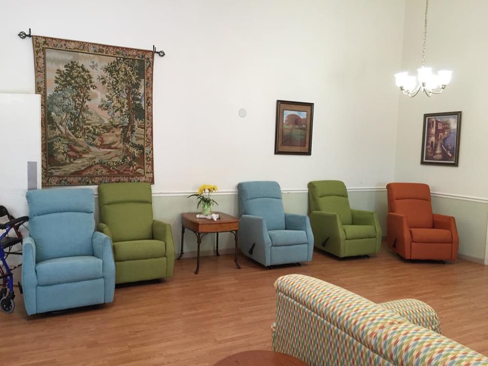 A cozy living room furnished with colorful recliner chairs and traditional decor.