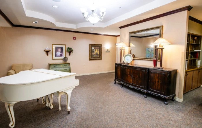 A well-decorated living space with a white piano and elegant furnishings.